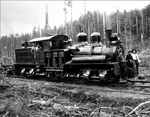 An early locomotive with thick forest in the background. Two men lean out of the locomotive and three more stand on its front. 